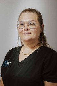 Woman in black scrubs smiling in headshot