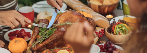 Turkey being cut on dinner table during Thanksgiving feast
