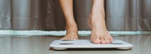 Woman stepping on scale on hard floor