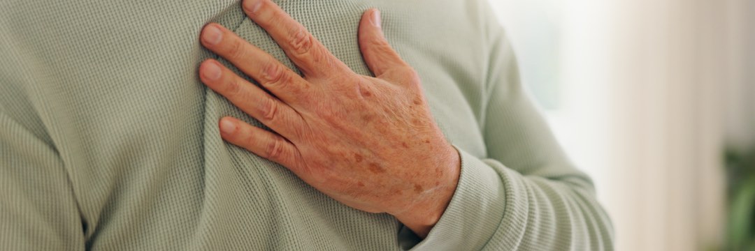 Older man grabbing chest suffering from heartburn 